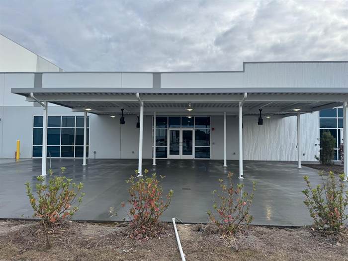 Finished concrete flatwork under a covered entry canopy at a commercial building