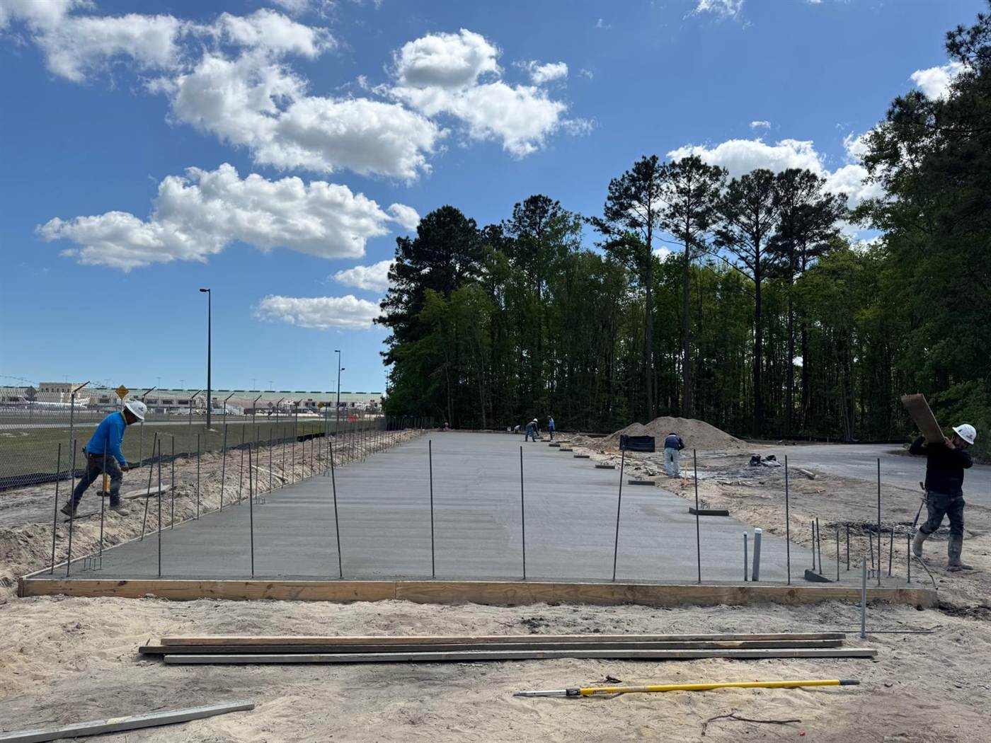 Commercial concrete slab sections poured in strips with dowels and reinforcement left exposed for the next placement