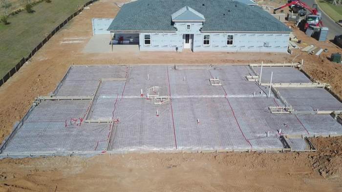 Aerial view of a residential foundation prepared with vapor barrier, mesh and plumbing rough-in
