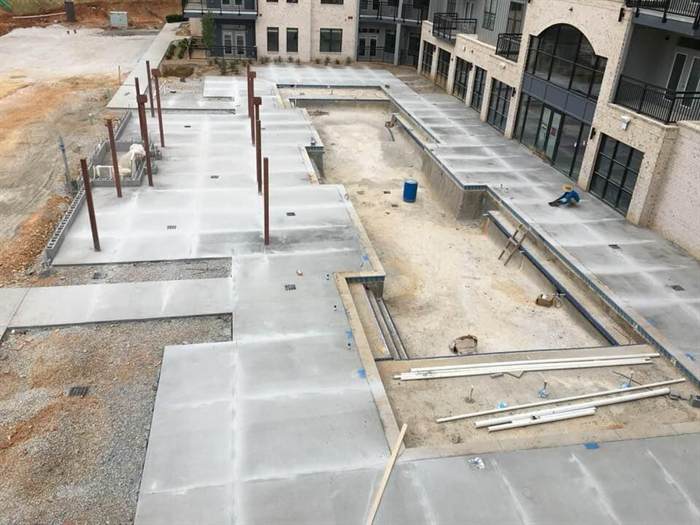 Finished concrete pool deck and courtyard flatwork between apartment buildings