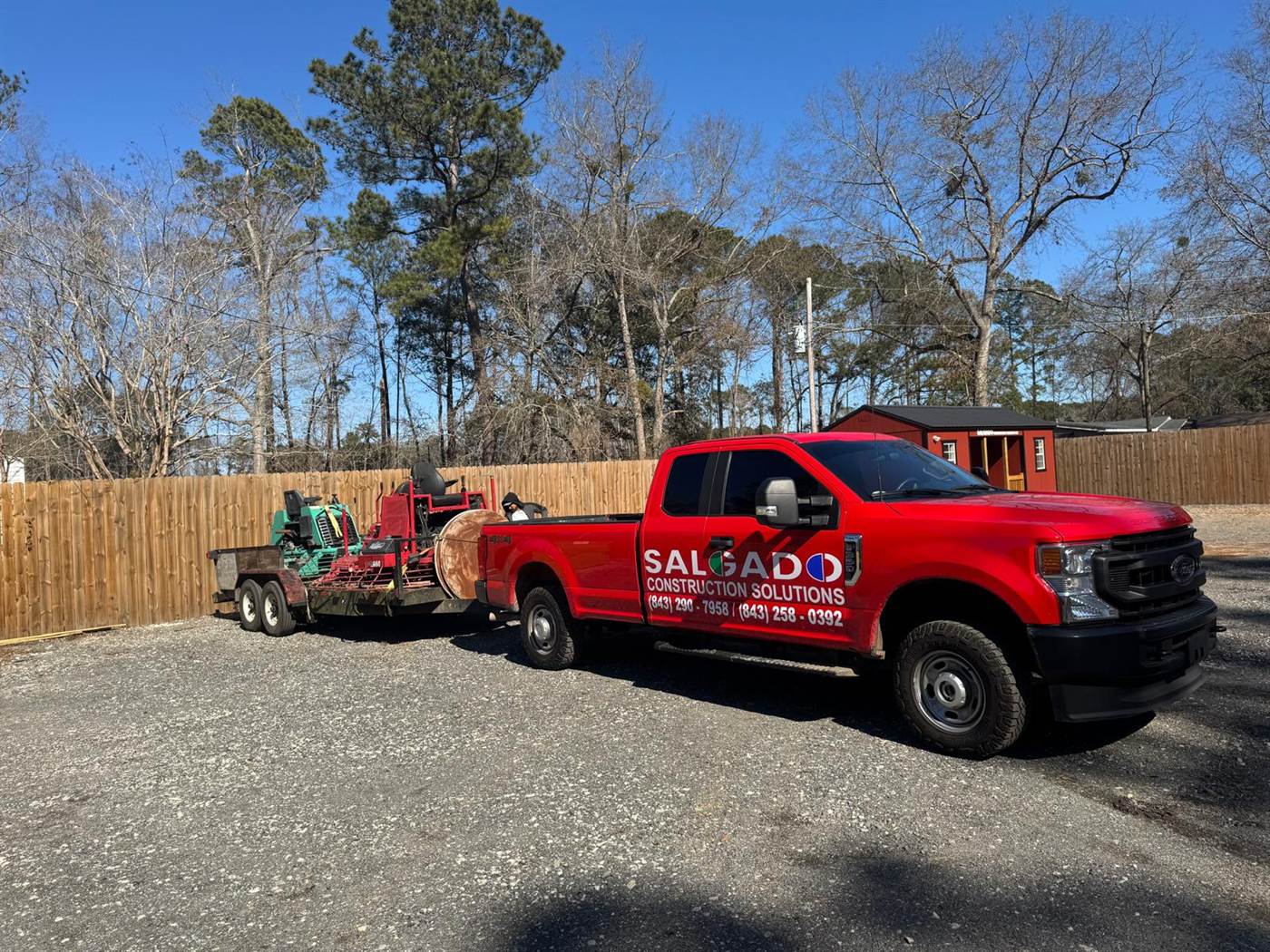 Salgado Construction Solutions pickup truck with a trailer carrying ride-on and walk-behind power trowels