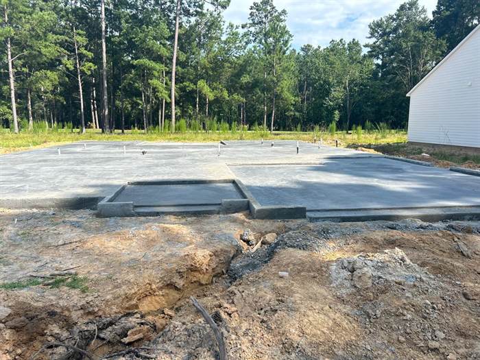 Finished house slab with a separate lowered porch slab and plumbing stub-ups