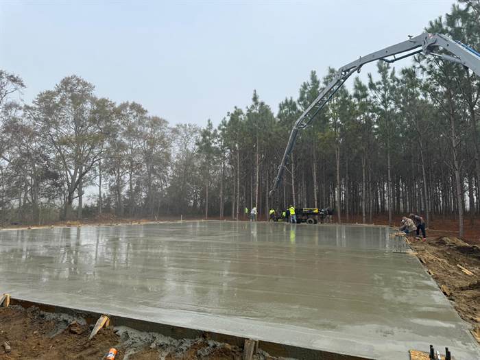 Large finished slab on a foggy morning with a boom pump extended over the pour