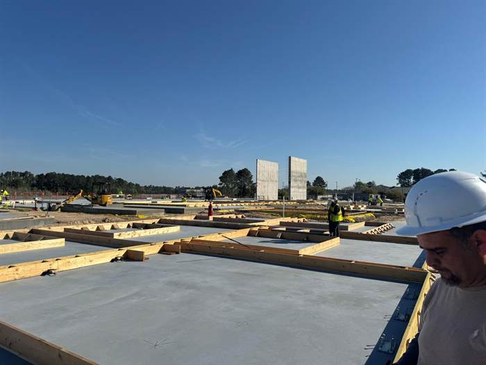 Commercial site with formwork laid out on finished slab sections and tilt-up wall panels standing